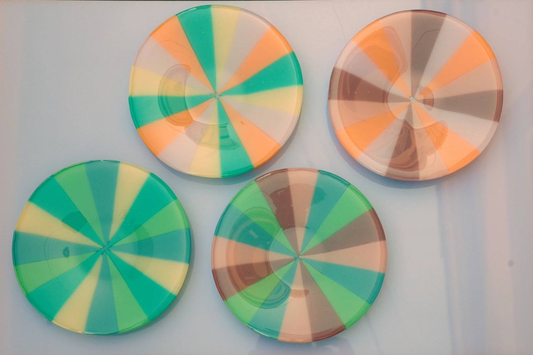 Four of Emiline Ensley's fused glass pinwheel dishes, photographed together
